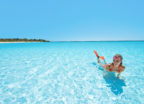 A lady smiling in a large-scale crystalline lagoon powered by Crystal Lagoons technology