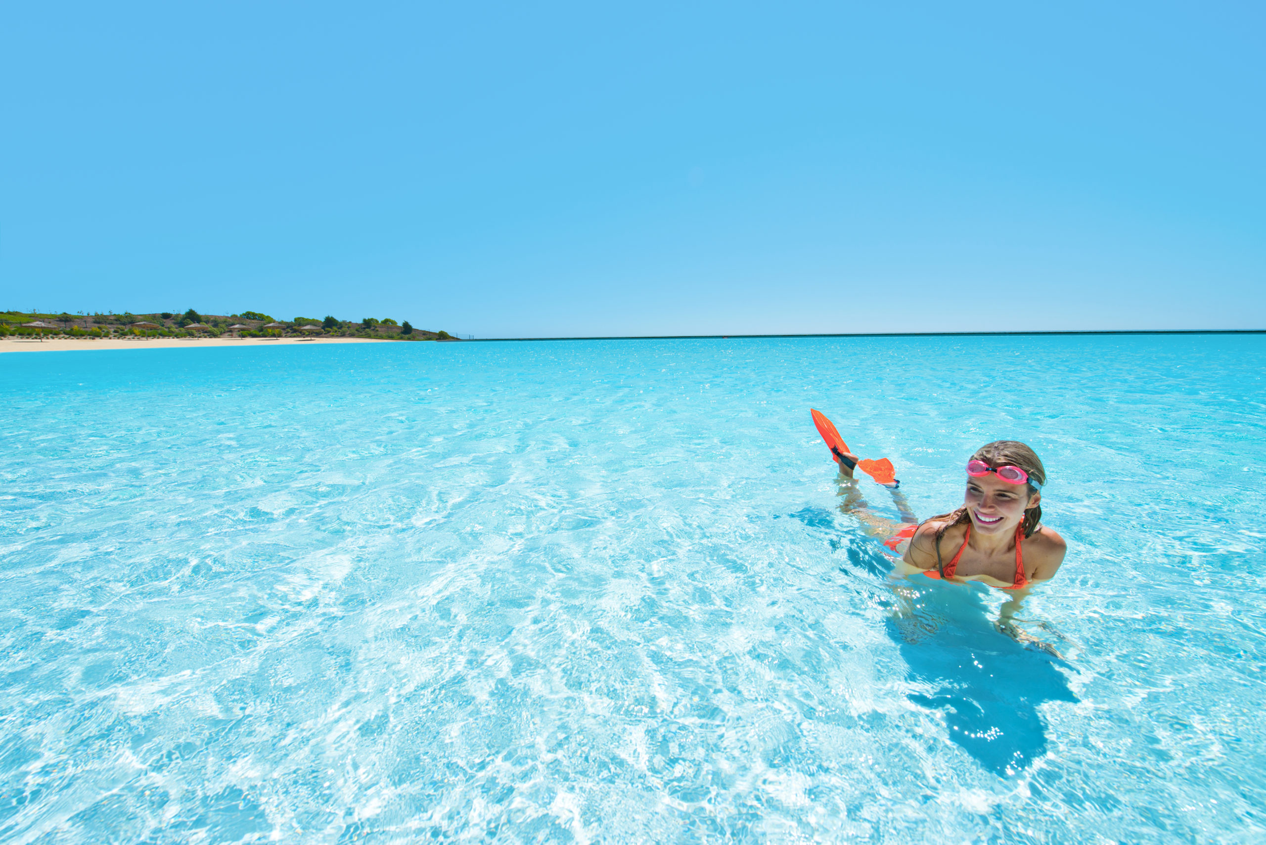 A lady smiling in a large-scale crystalline lagoon powered by Crystal Lagoons technology