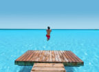 Man jumping into a large-scale pure turquoise lagoon powered by Crystal Lagoons