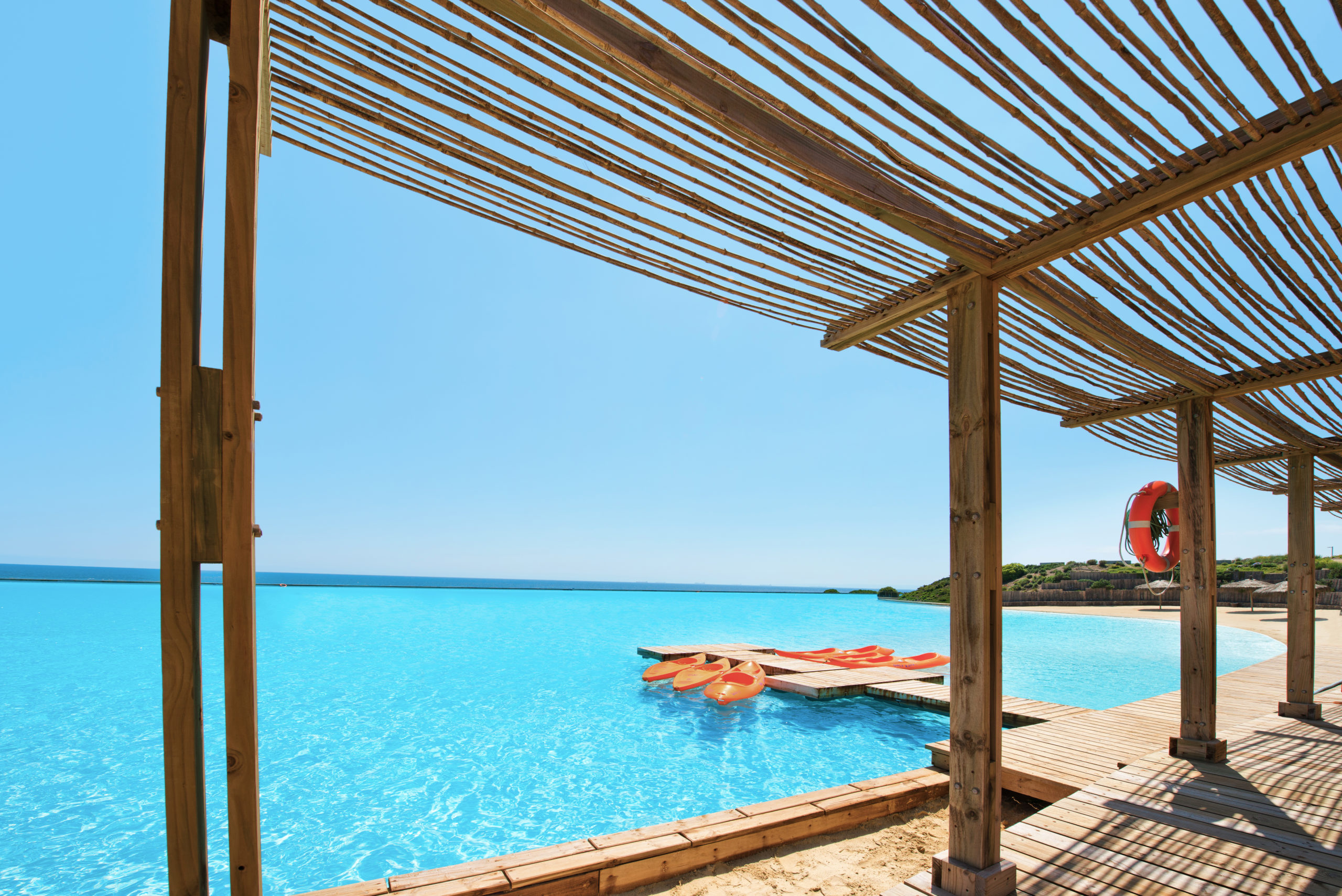 View overlooking a pure turquoise, large- man-made lagoon with two orange kayaks