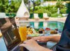 Woman working on her laptop by a resort pool