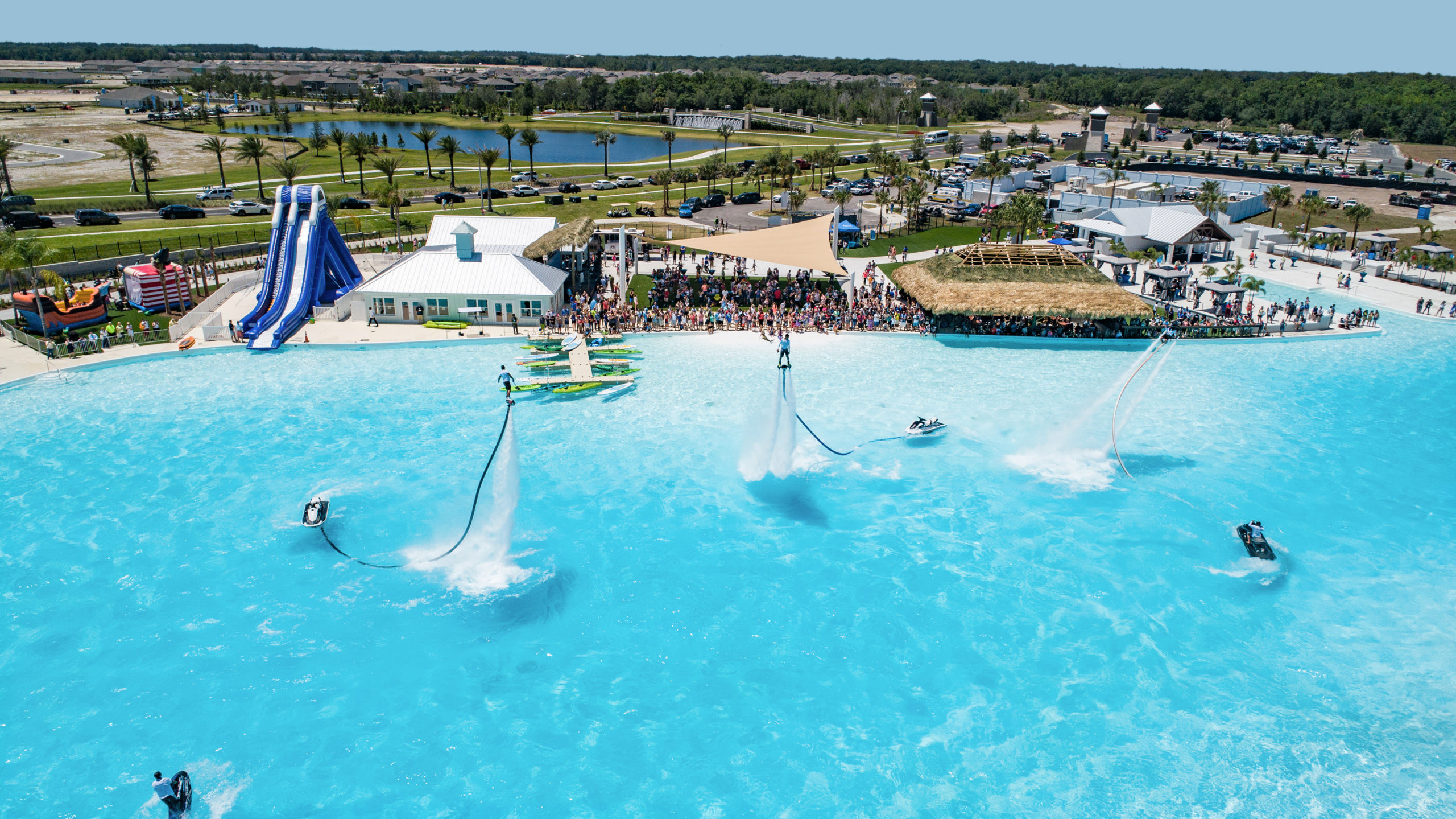 Aerial view of a crystal clear lagoon with people doing watersports on a sunny day